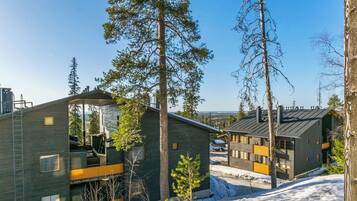 A modern cabin-style building with a sloped roof, large windows, and a visible deck area.