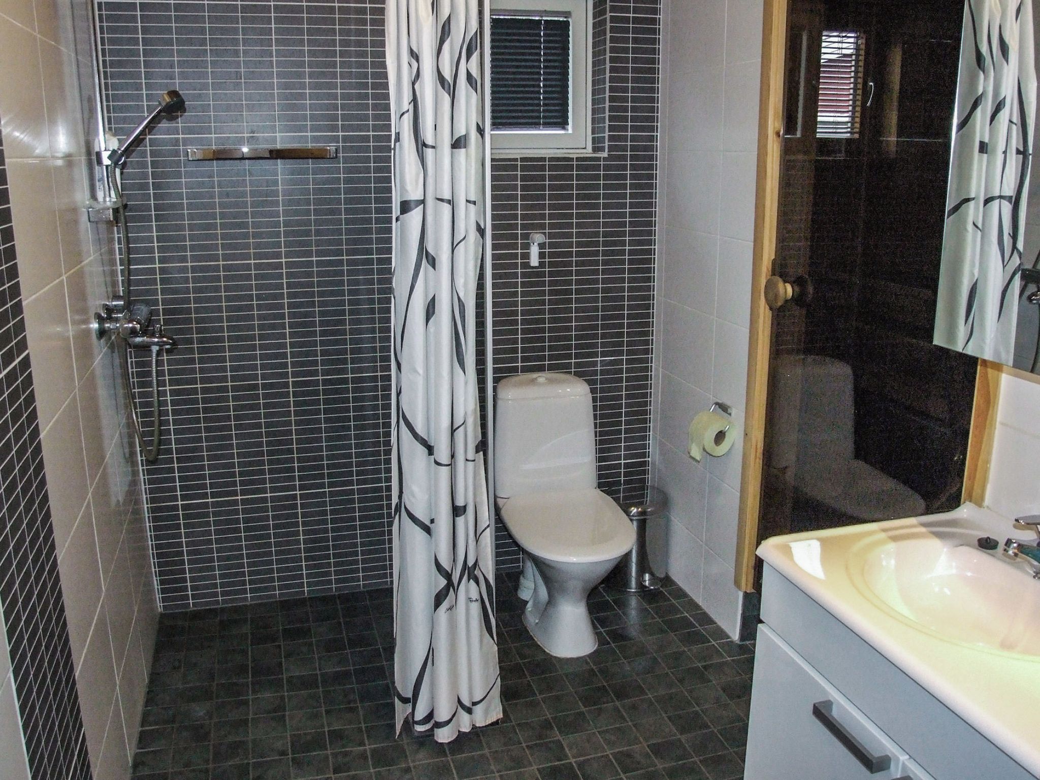 A bathroom with a shower, toilet, and sink.