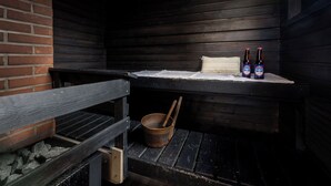 Un banc en bois rustique, avec un seau en métal et une bouteille de bière posés sur une table.