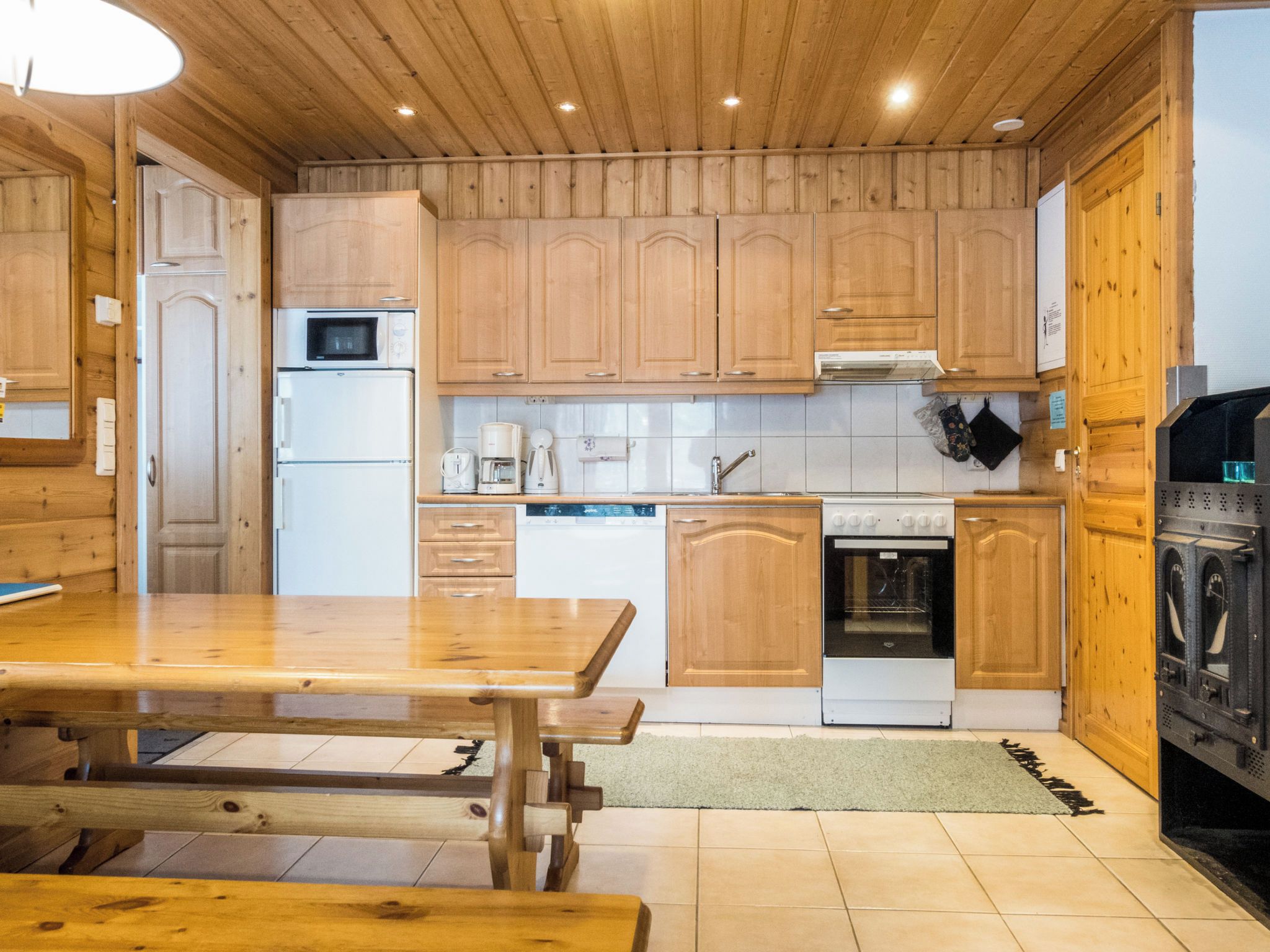 A wooden kitchen with a built-in oven, microwave, and coffee maker.