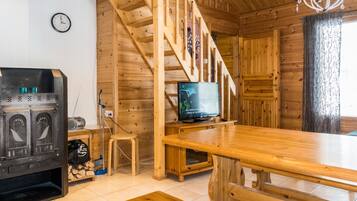 Ein Holzinnenraum mit Treppe, Fernseher, Kamin und einer Wanduhr.