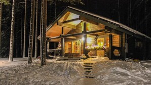 A wooden cabin with a covered porch, surrounded by snow. - Hamppulahti by Interhome (Kuhmo)