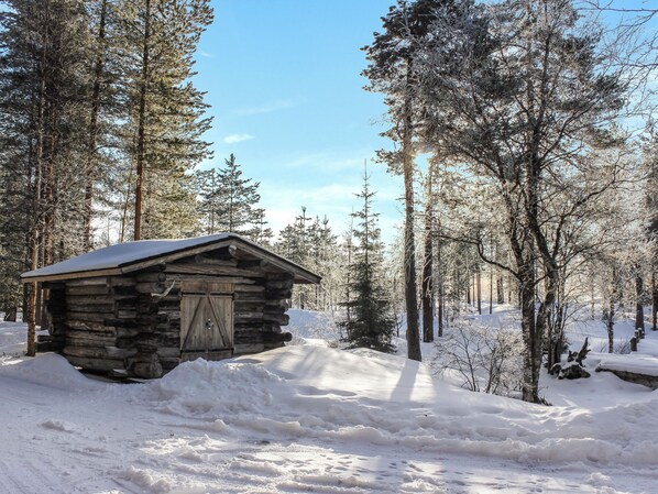 A log cabin surrounded by snow-covered trees.