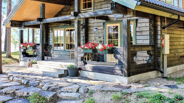 A log cabin with a porch, stone steps, and flower boxes. - Hamppulahti by Interhome (Kuhmo)