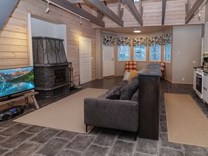 A cozy living room with a stone fireplace, a television, and a sofa. - Rukan taikavuosseli 12 a by Interhome (Kuusamo)