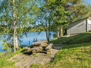 A lakeside picnic area with wooden benches and a shed. - Vacation home Tarvas by Interhome (Parikkala)