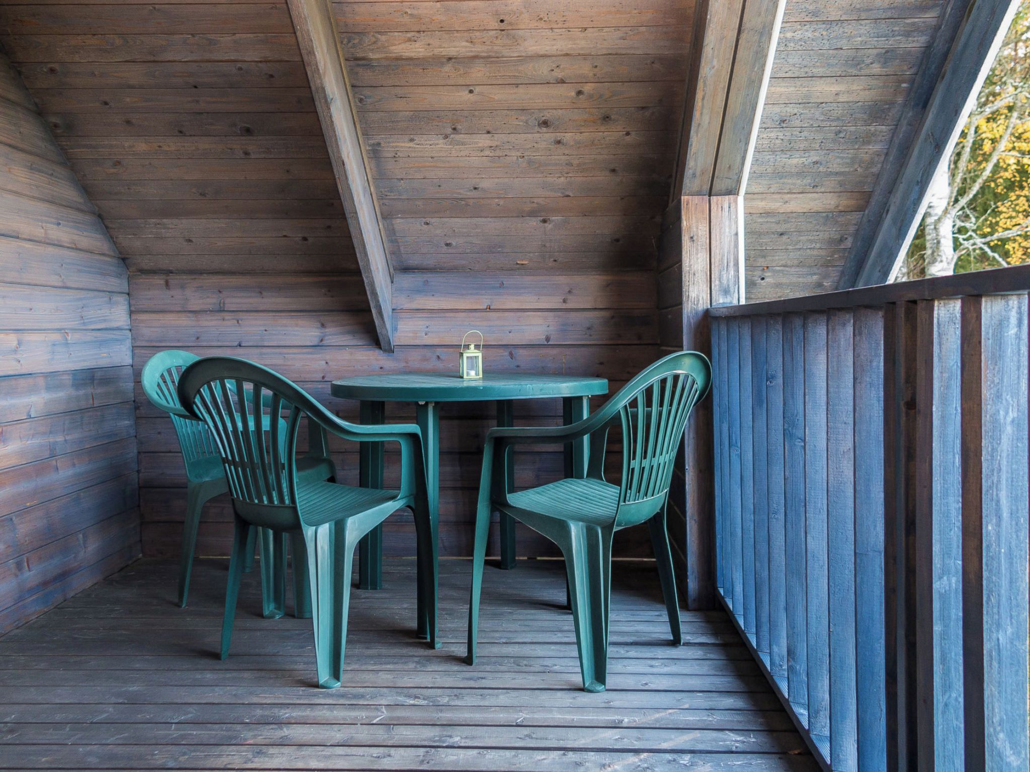 A wooden deck with a table and two chairs.