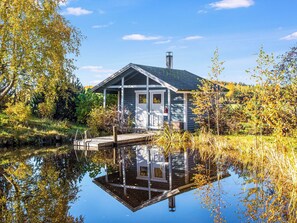 A house with a dock extending into a calm body of water, surrounded by autumn foliage. - Iltarusko by Interhome (Nilsiä)