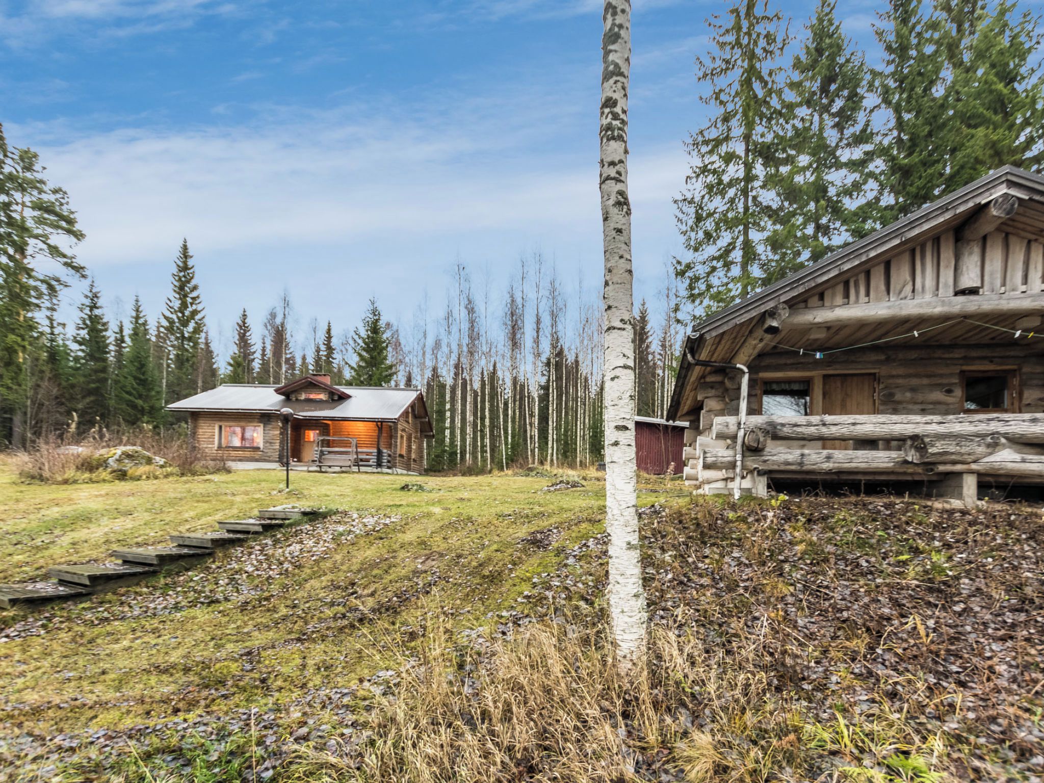 Une cabane avec une façade en bois, un toit en métal et une cheminée bien visible.