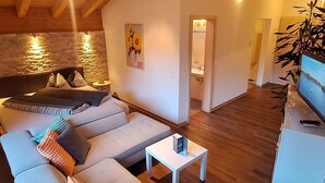 Una sala moderna con un sofá, una mesita y un televisor.