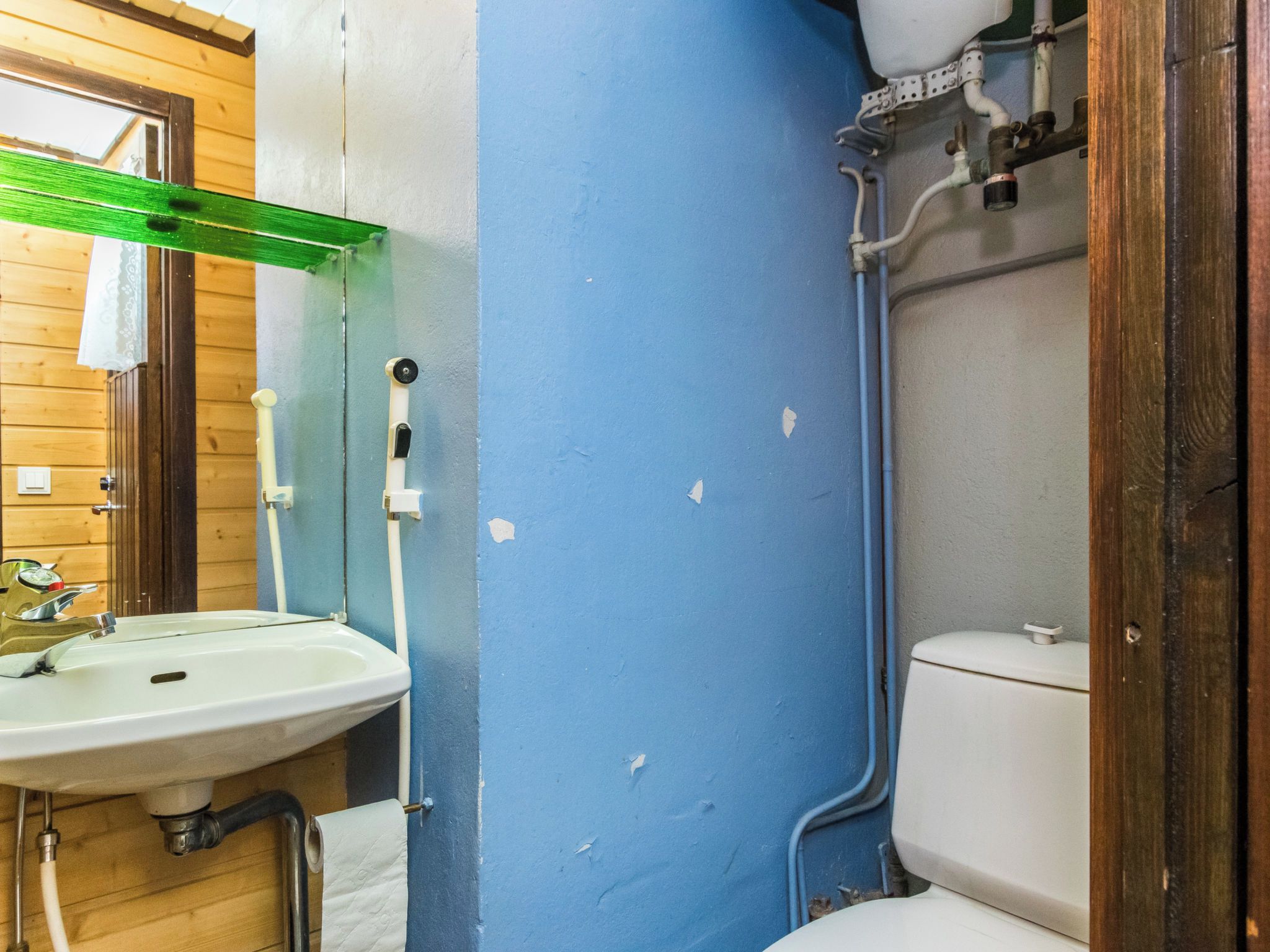A bathroom with a sink, toilet, and blue walls.