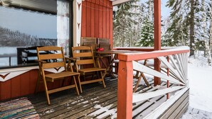 A wooden deck with a table and chairs, overlooking a snowy landscape. - Lepikko by Interhome (Kaavi)