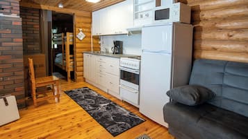 Un espacio habitable compacto con kitchenette, un sofá, una cafetera y un microondas.