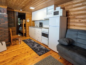 A compact living space with a kitchenette, a sofa, a coffee machine, and a microwave.