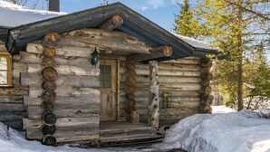 A rustic log cabin with a wooden door and a small porch.