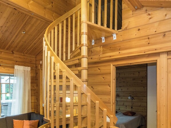 A wooden interior with a spiral staircase leading to an upper level.