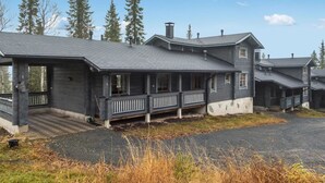 A two-story house with a porch, a chimney, and a driveway.