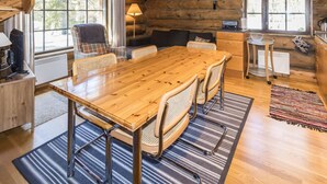 A cozy cabin interior with a wooden dining table, chairs, a sofa, and a kitchen area. - Örtsylä a by Interhome (Salla)