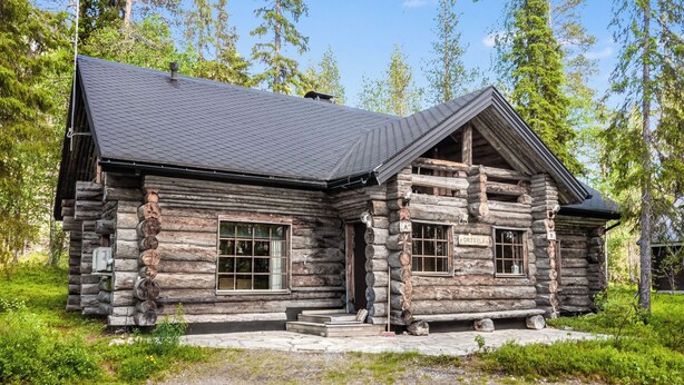 A log cabin with a sloped roof, large windows, and a stone foundation. - Örtsylä a by Interhome (Salla)