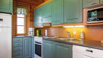 A kitchen with teal cabinets, a white refrigerator, a stove, a microwave, and a dishwasher.