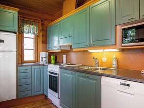 A kitchen with teal cabinets, a white refrigerator, a stove, a microwave, and a dishwasher.