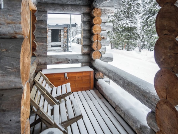 A log cabin with a bench and a wooden bench outside.