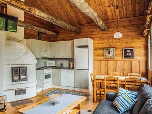 Interior acogedor de una cabaña con cocina, comedor y chimenea.