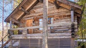 Una cabana de fusta amb façana de fusta, un porxo i una escala cap a l'entrada.