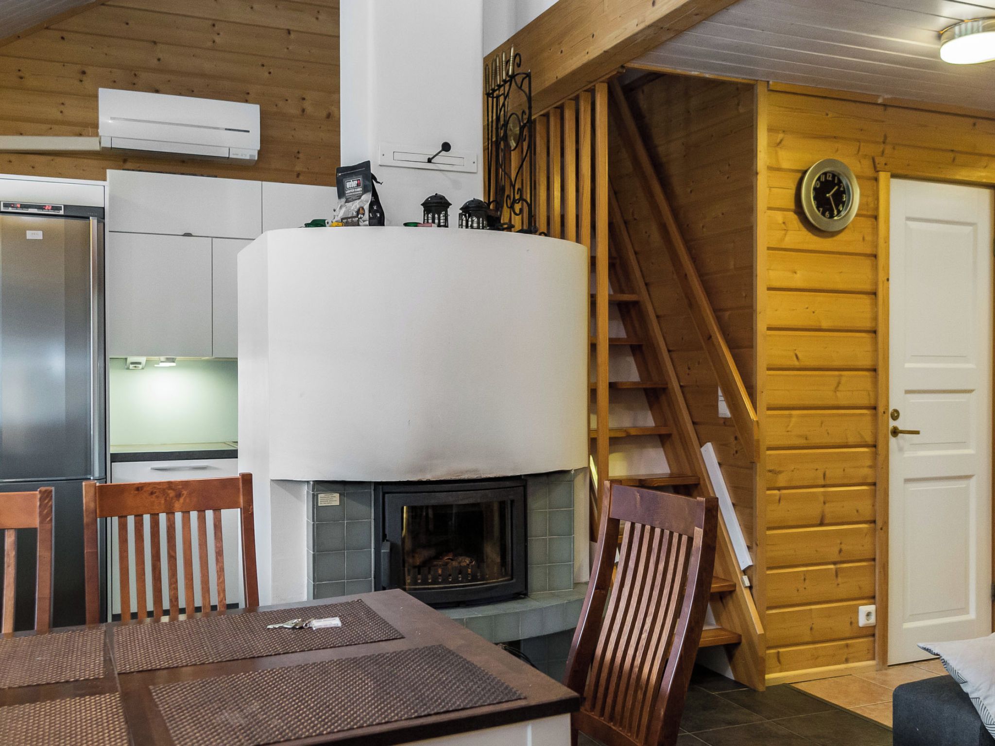 Eine moderne Küche mit eingebautem Herd, Holzwänden und einer Treppe zu einer oberen Ebene.