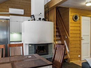 Een moderne keuken met een ingebouwde kookplaat, houten wanden en een trap naar een hoger gelegen verdieping.