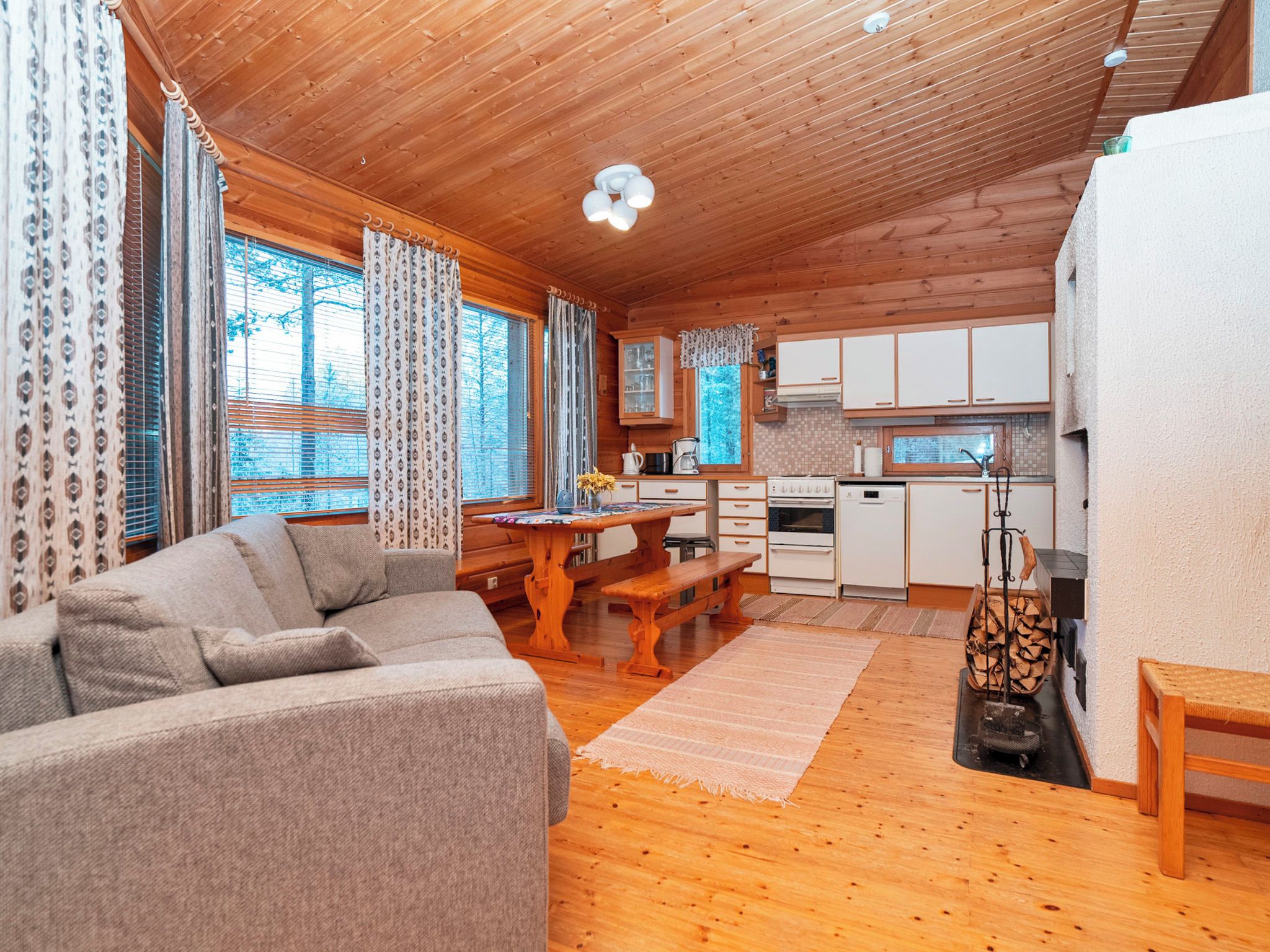 Un interior de cabaña acogedor con sala de estar, comedor y cocina.