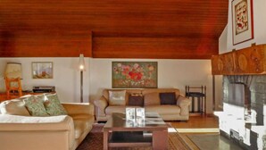 A cozy living room with a fireplace, a sofa, a coffee table, and a rug.