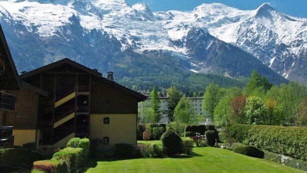 Un chalet in montagna con vista su cime innevate.