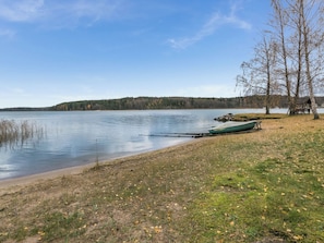 A lakeside view with a dock, a small wooden structure, and a forested hill in the background. - Satulinna by Interhome (Kemiönsaari)