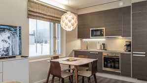 A modern kitchen with dark wood cabinets, a microwave, and a coffee maker.