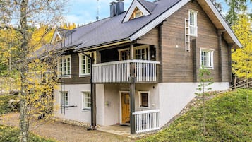 A two-story wooden house with a balcony, a chimney, and a door labeled 'DUETTO'.