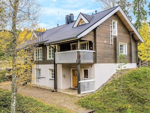 A two-story wooden house with a balcony, a chimney, and a door labeled 'DUETTO'.
