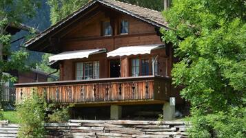 Eine Holzhütte mit Balkon, umgeben von Bäumen.