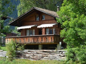Eine Holzhütte mit Balkon, umgeben von Bäumen.