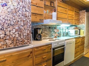 A kitchen with wooden cabinets, a stove, a microwave, and a coffee maker.