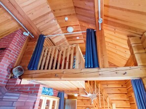 A wooden interior with a balcony, a brick wall, and a ceiling with exposed beams. - Vuonkuma by Interhome (Äkäslompolo)