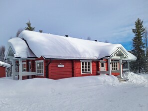 A red building with a snow-covered roof, surrounded by snow. - Vuonkuma by Interhome (Äkäslompolo)
