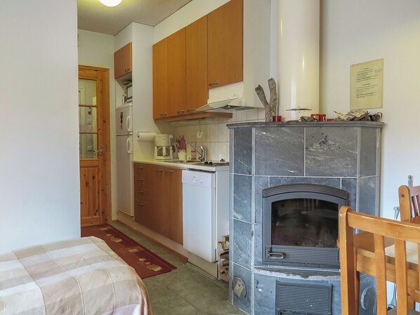 A compact kitchen with wooden cabinets, a built-in stove, and a small refrigerator.
