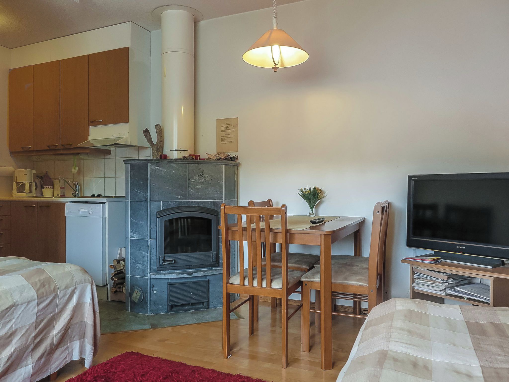 Een knus woongedeelte met kitchenette, open haard, eethoek en televisie.