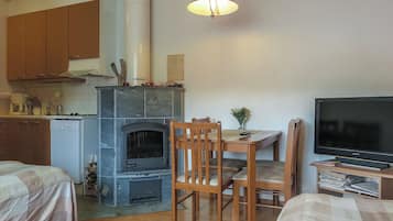 Een knus woongedeelte met kitchenette, open haard, eethoek en televisie.
