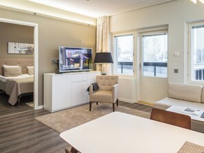 A modern living room with a television, a sofa, a chair, and a dining table. - Tahko spa red - vuori apartment by Interhome (Nilsiä)