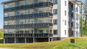 Un edificio a più piani con un design architettonico moderno, caratterizzato da balconi e ampie finestre.