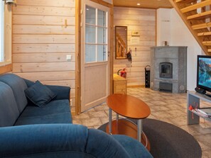 A cozy living room with a blue sofa, a small wooden table, and a fireplace.