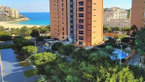 Ein mehrstöckiges Hotel mit Pool und Meerblick.