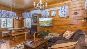 A wooden cabin interior with a sofa, a chair, a table, and a bench. - Sallanrinne b by Interhome (Salla)
